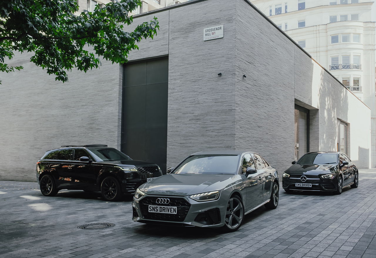 The same three SNS vehicles from a lower angle, outside the stone building on Grosvenor Hill, W1