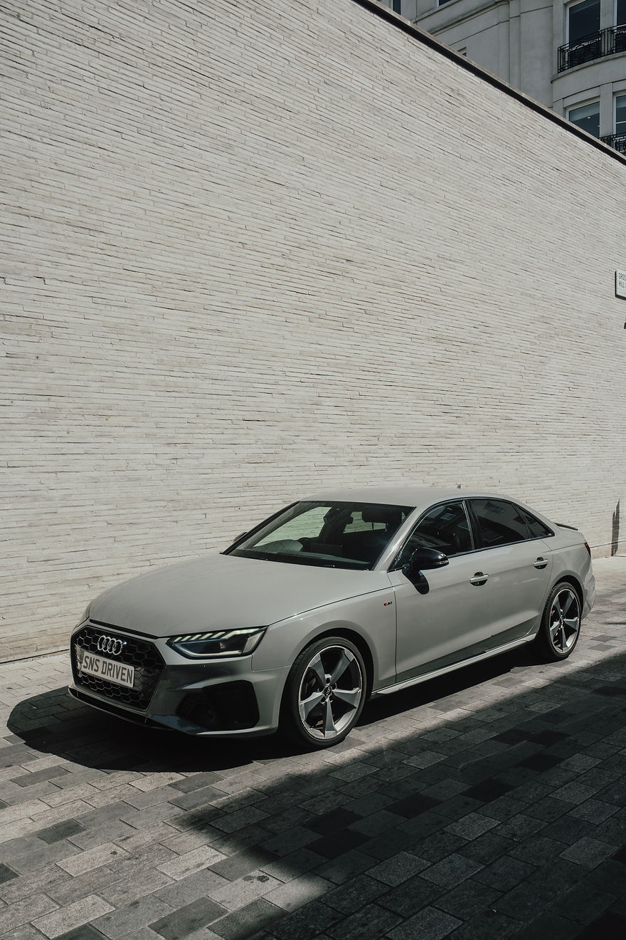 Audi A4, low front view with headlights lit, outside the SNS building on Grosvenor Hill